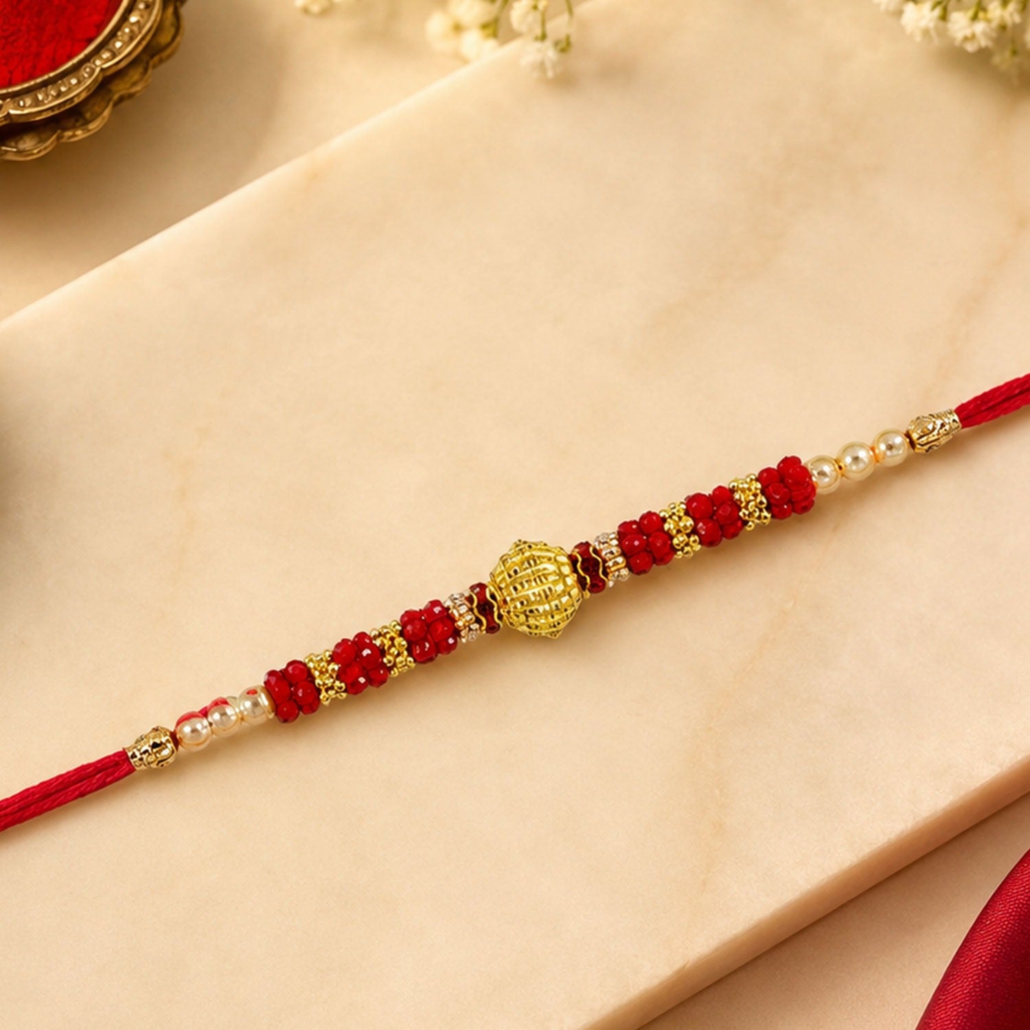 Red Bead Rakhi – Golden Centerpiece & Pearl Details